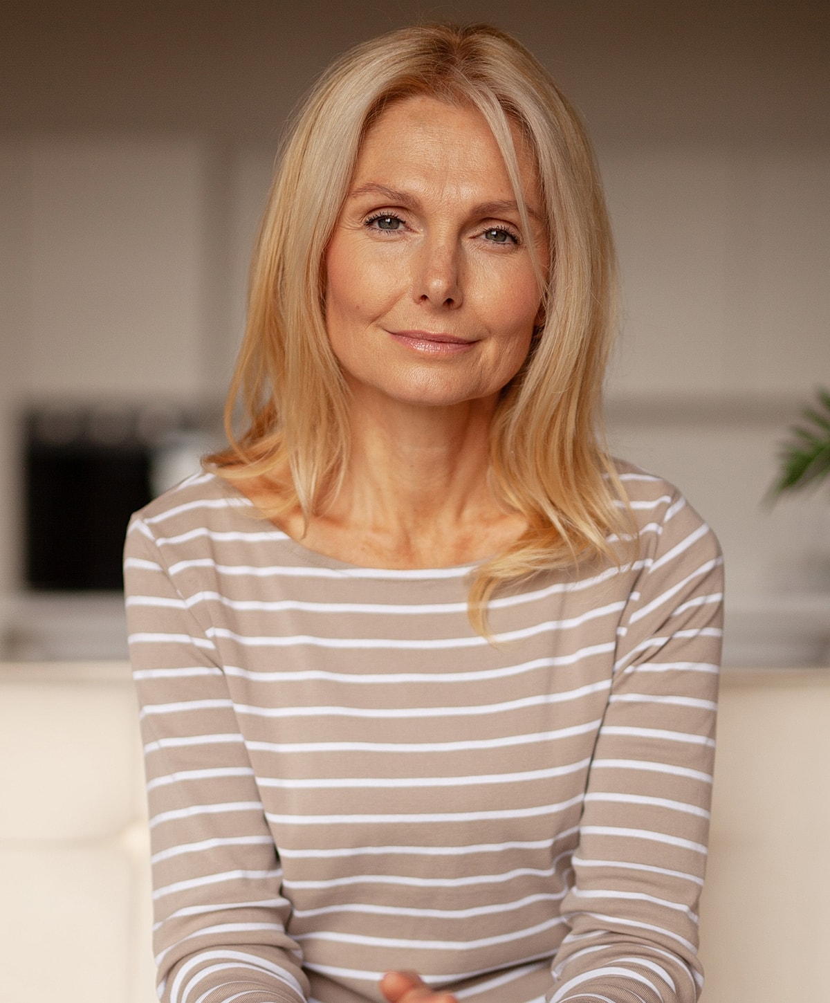 Smiling woman with blonde hair in striped shirt.