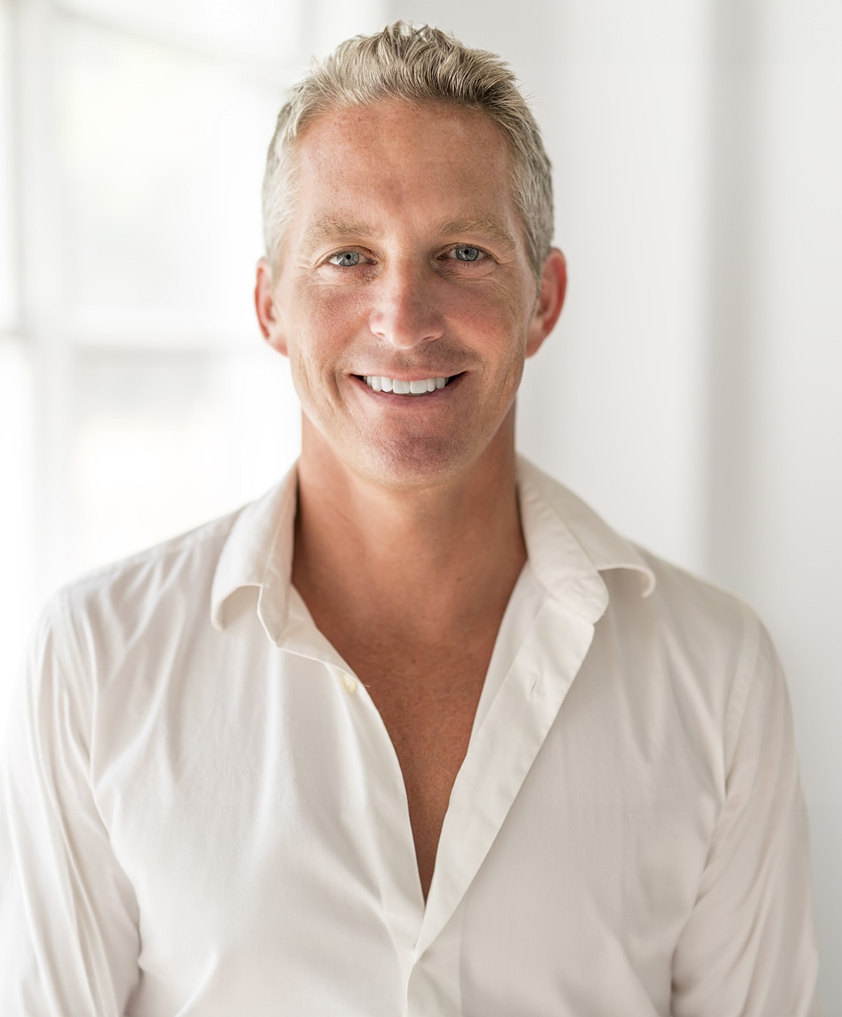 Smiling man in a white shirt, portrait style.