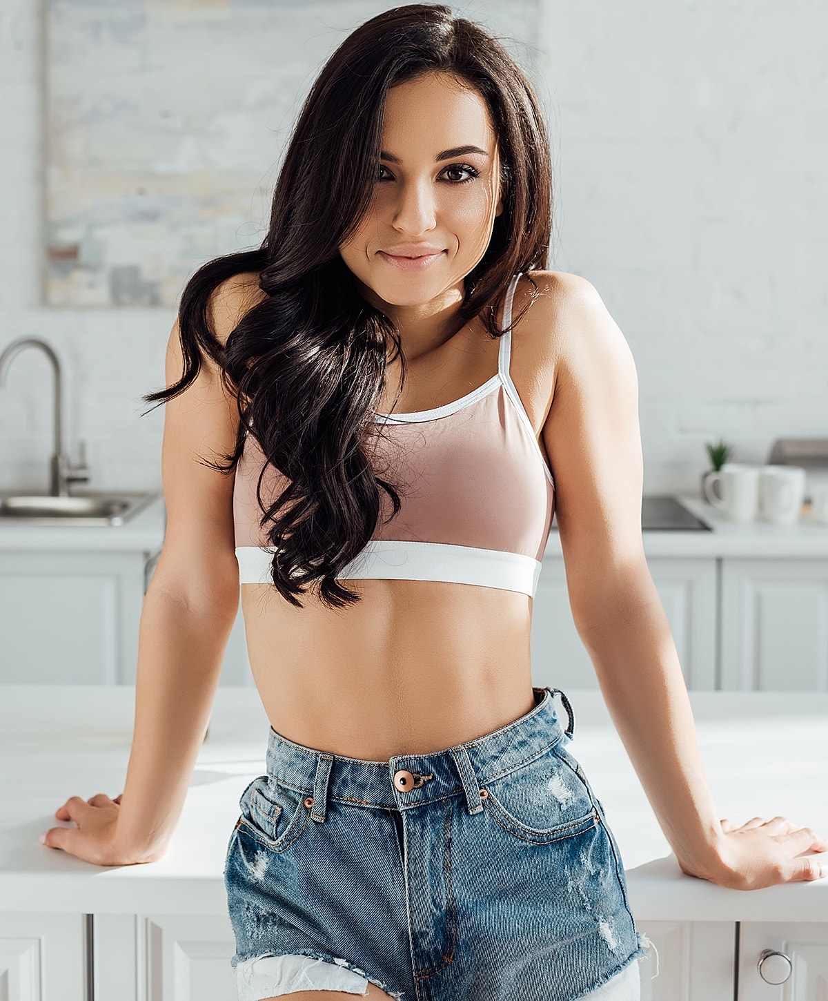 Woman in casual outfit posing in kitchen.